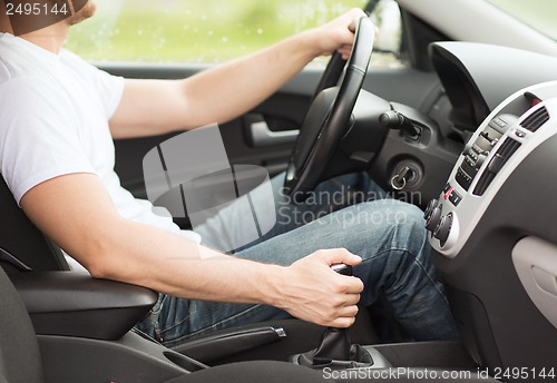 Image of man shifting the gear on car manual gearbox