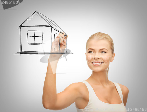 Image of woman drawing house on virtual screen