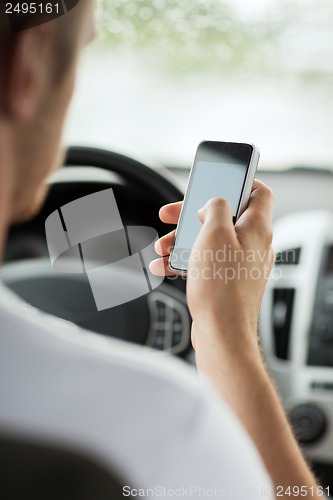 Image of man using phone while driving the car