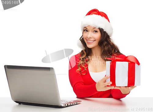 Image of woman with gift box and laptop computer