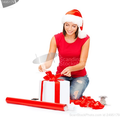 Image of smiling woman in santa helper hat with gift box