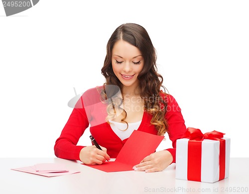 Image of smiling woman in red clothes with postcard