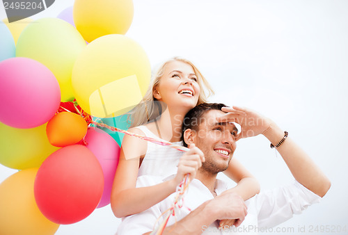 Image of couple with colorful balloons at seaside
