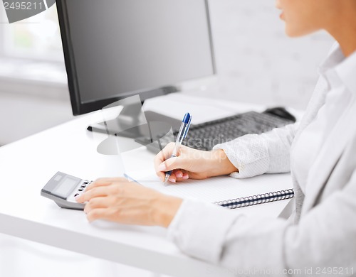 Image of businesswoman with notebook and calculator