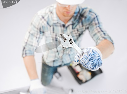 Image of man with ladder, toolkit and spanner