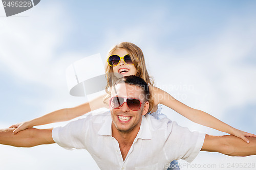 Image of happy father and child in sunglasses over blue sky