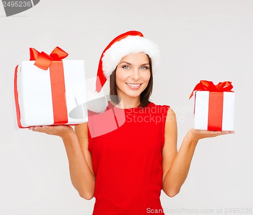 Image of woman in santa helper hat with many gift boxes