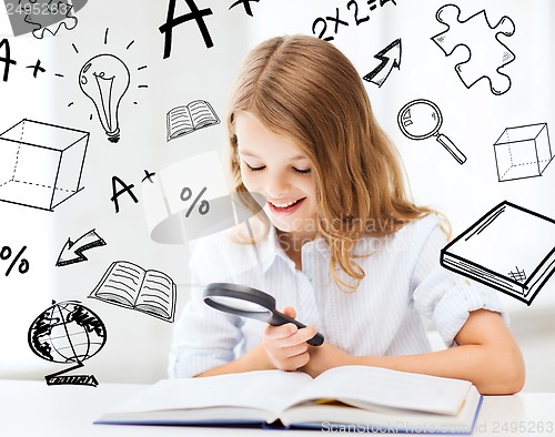 Image of girl reading book with magnifier at school