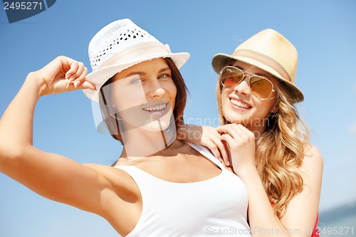 Image of girls in hats on the beach