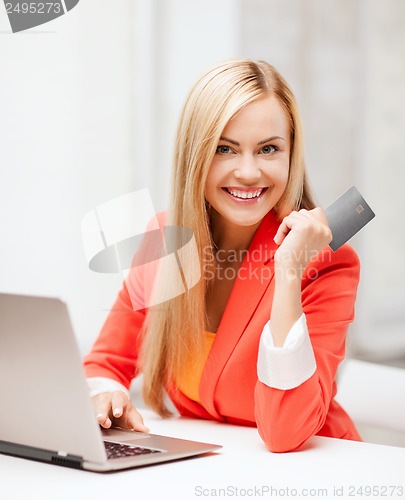 Image of businesswoman with laptop using credit card
