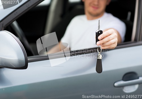 Image of man with car key outside