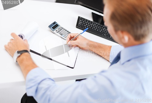 Image of businessman with notebook and calculator