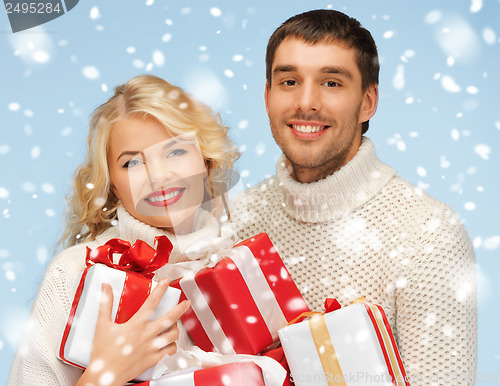 Image of happy man and woman with many gift boxes