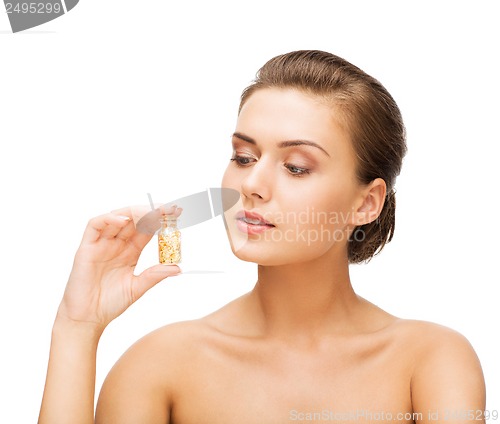 Image of beautiful woman showing bottle with golden dust