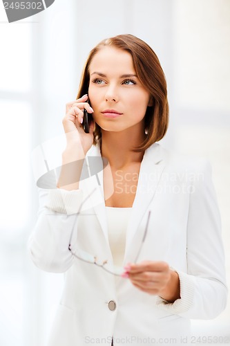 Image of businesswoman with smartphone in office