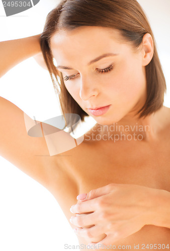 Image of woman checking breast for signs of cancer