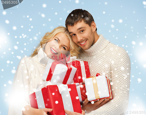 Image of happy man and woman with many gift boxes