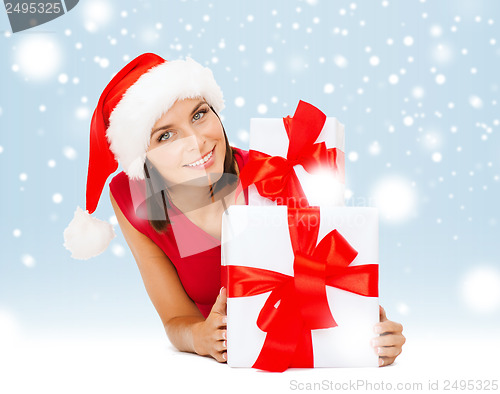 Image of smiling woman in santa helper hat with gift boxes