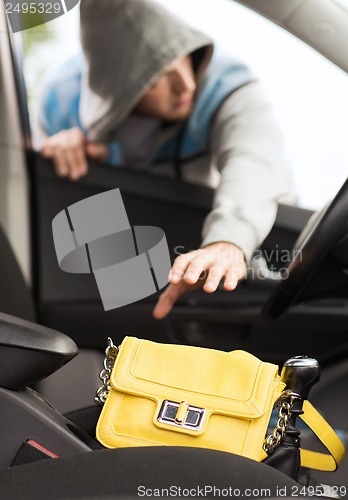 Image of thief stealing bag from the car