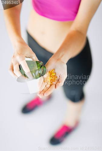 Image of woman hand with capsules