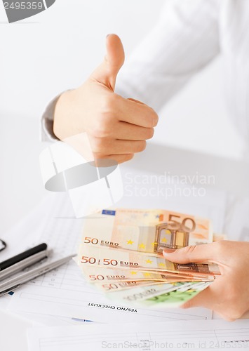Image of woman hands with euro cash money and thumbs up