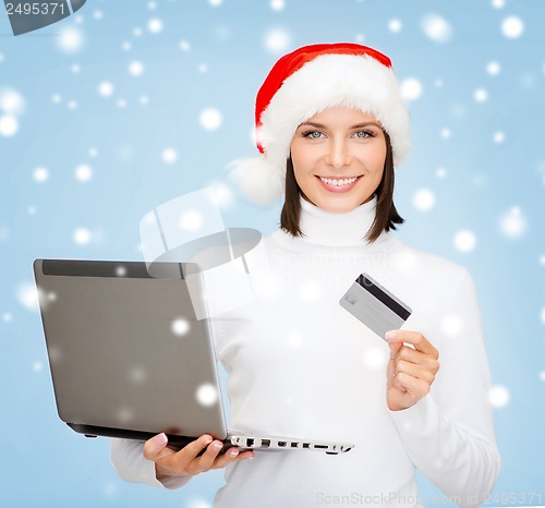 Image of woman in santa hat with laptop and credit card