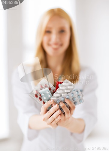 Image of female doctor with packs of pills