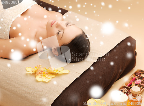 Image of woman in spa salon lying on the massage desk