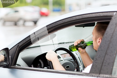 Image of man drinking alcohol while driving the car