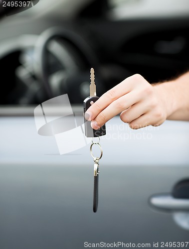 Image of man with car key outside