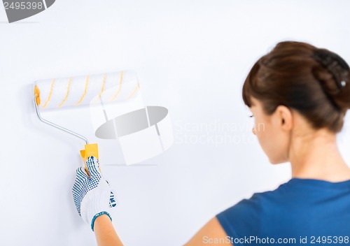Image of woman with roller and paint colouring the wall