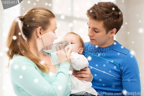 Image of family and adorable baby with feeding-bottle