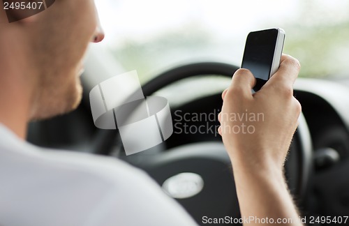 Image of man using phone while driving the car