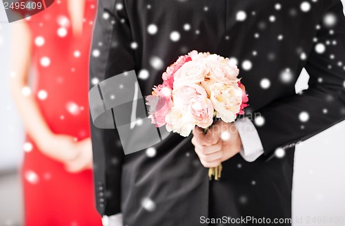 Image of man hiding bouquet of flowers