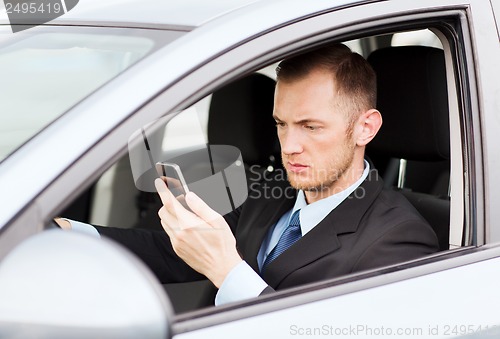 Image of man using phone while driving the car