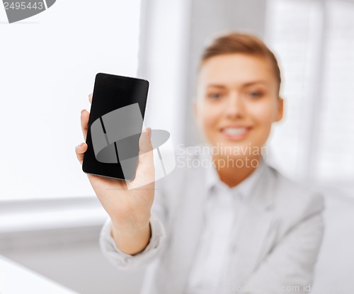 Image of businesswoman with smartphone in office