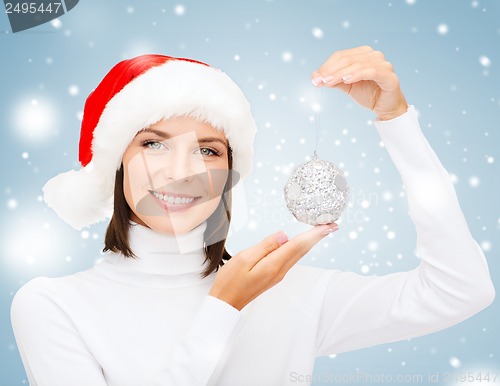 Image of woman in santa helper hat with christmas ball