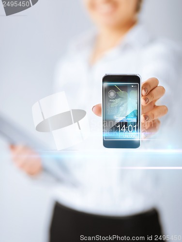 Image of woman with smartphone and virtual screens