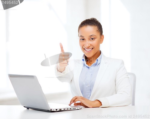 Image of businesswoman with laptop showing thumbs up