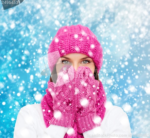 Image of surprised woman in hat, muffler and mittens