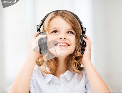 Image of little girl with headphones at home