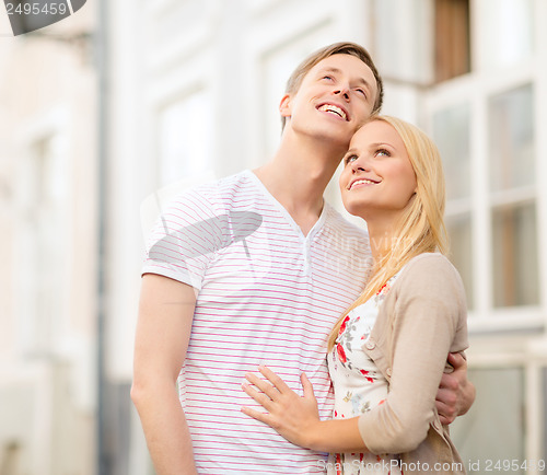 Image of romantic couple in the city looking up