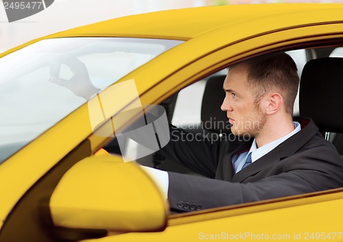 Image of businessman or taxi driver driving a car