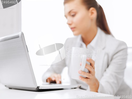 Image of businesswoman with laptop in office