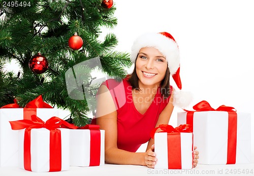 Image of smiling woman in santa helper hat with gift boxes