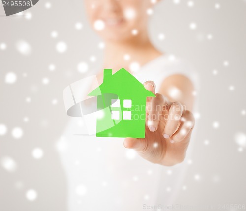 Image of woman hands holding green house