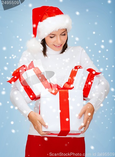 Image of woman in santa helper hat with many gift boxes