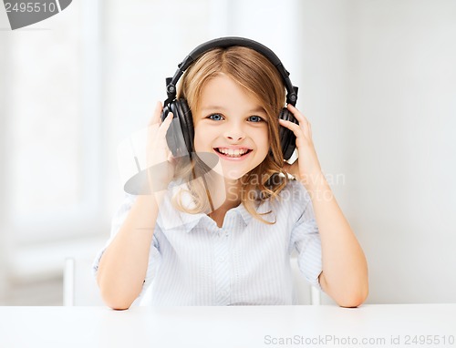 Image of little girl with headphones at home