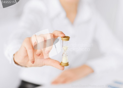 Image of woman hand with sandglass