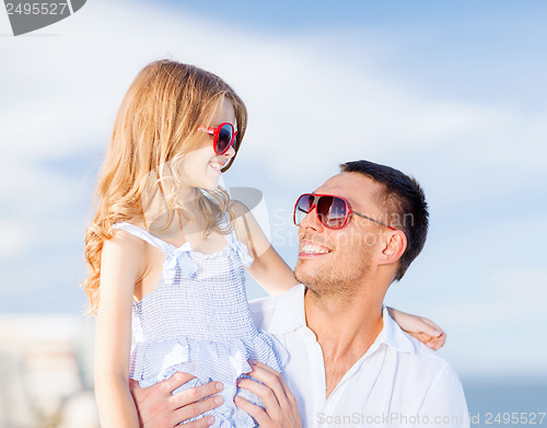 Image of happy father and child in sunglasses over blue sky